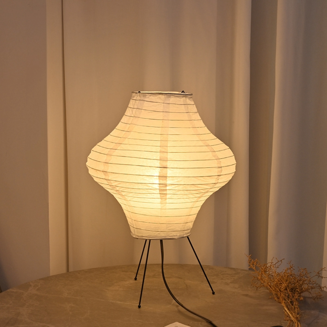 Paper Desk Lamp, Diamond Shape on table with paper lantern, plant, chair legs, and wire.