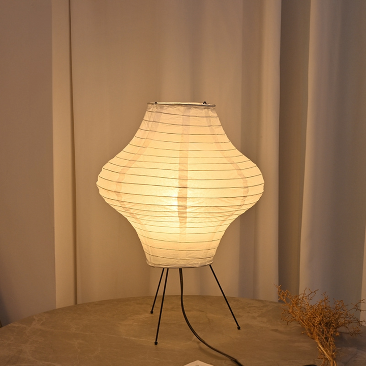 Paper Desk Lamp, Diamond Shape on table with paper lantern, plant, chair legs, and wire.