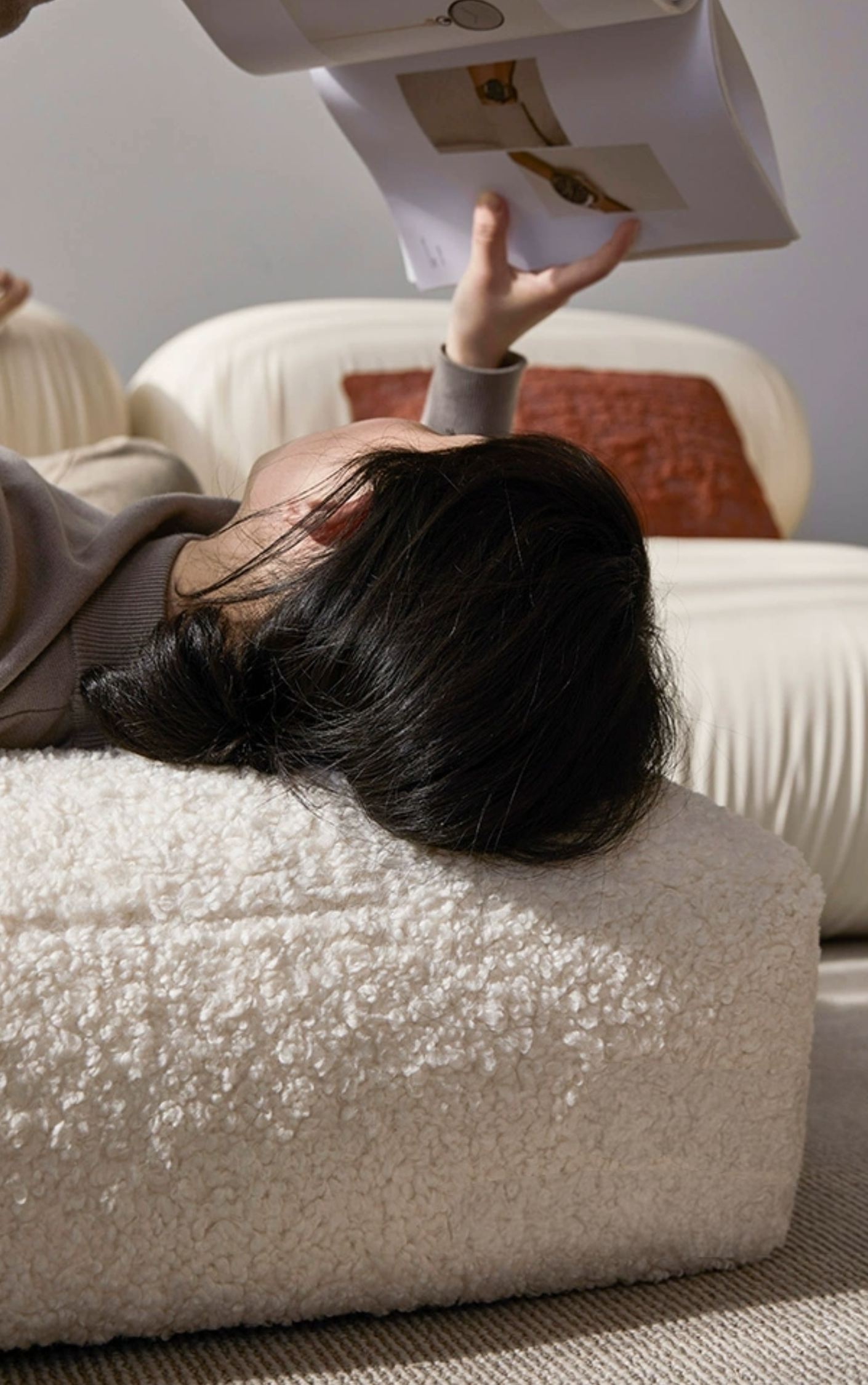 Cozy white fluffy bean bag chair cushion with person reading.