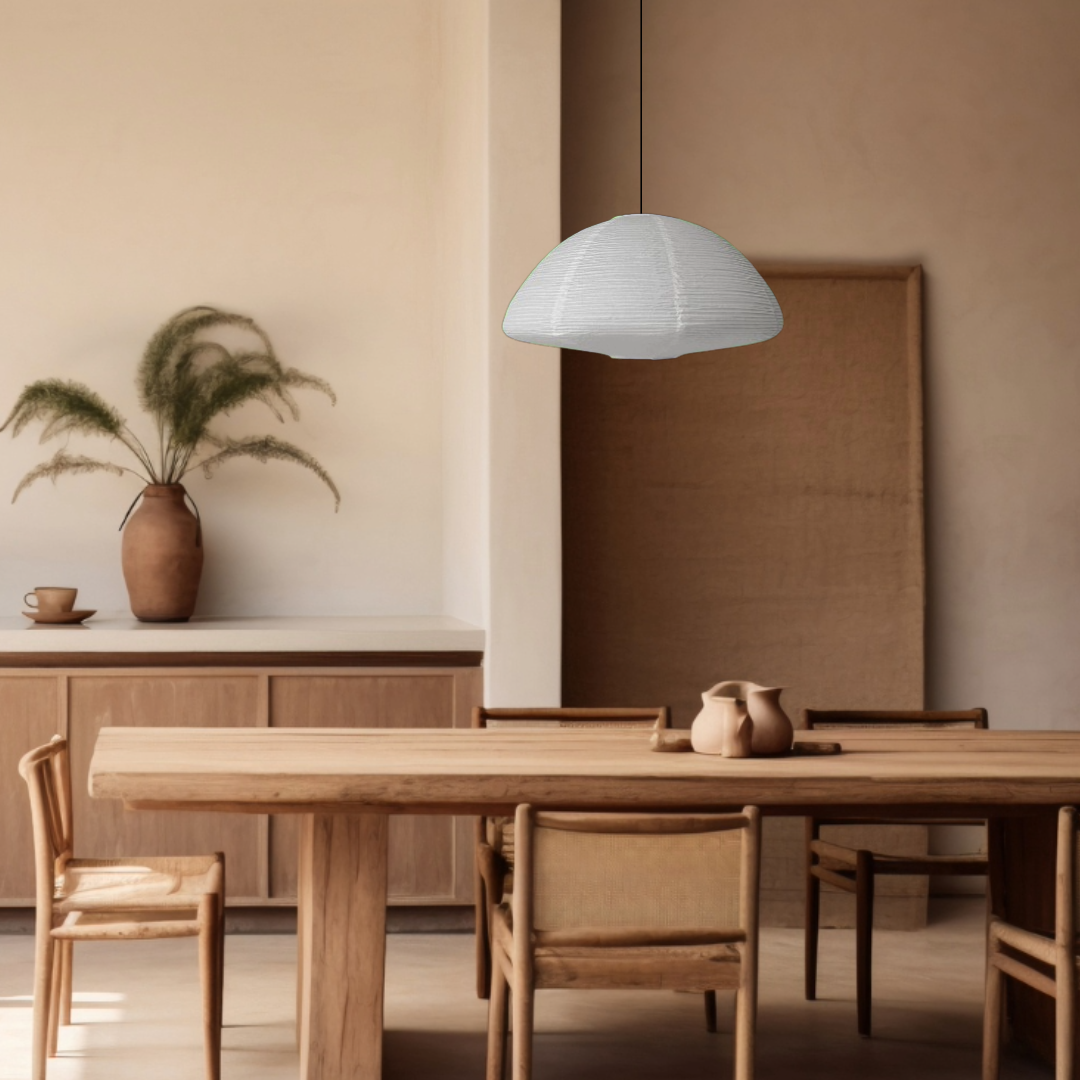 White paper lampshade, half circle shaped, hanging above a wooden dining table in a warm home decor setting.