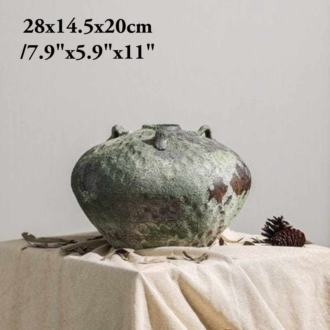 Wabi-Sabi Distressed Vase in textured gray tones, set on draped linen with pinecone accent.