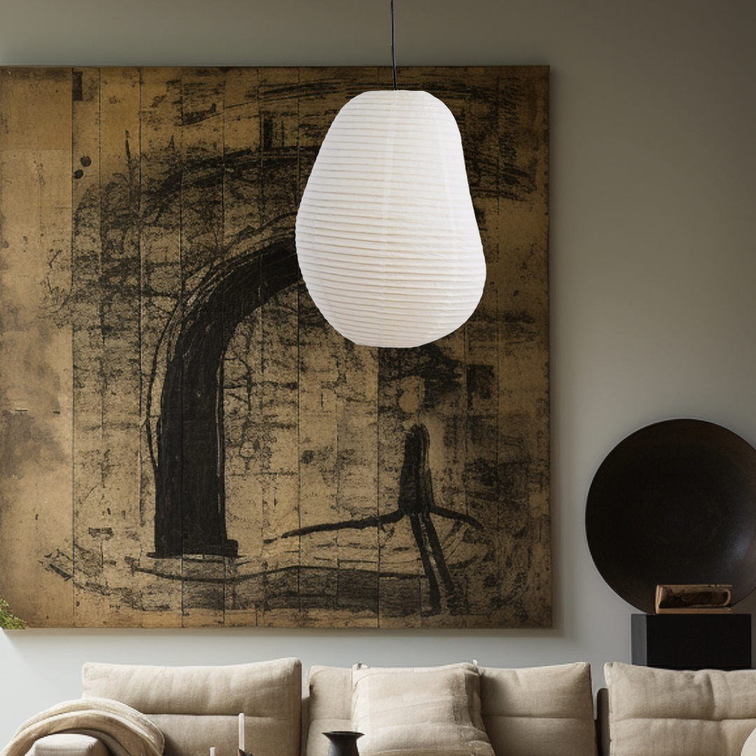 White paper lampshade, irregular shape, hanging over a beige sofa and artwork.
