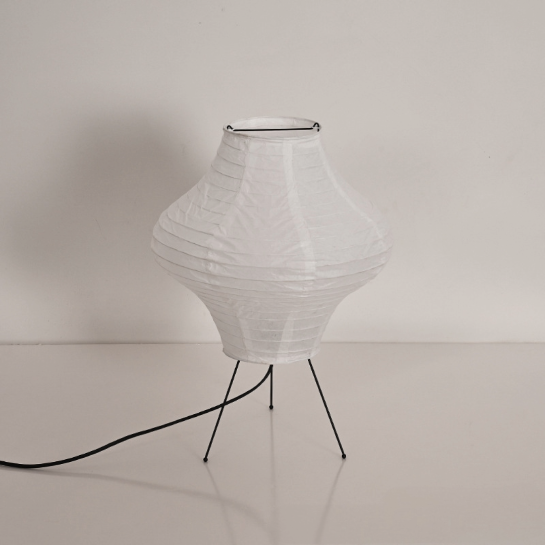 White paper diamond shape desk lamp on a minimalist stand with a black cord.