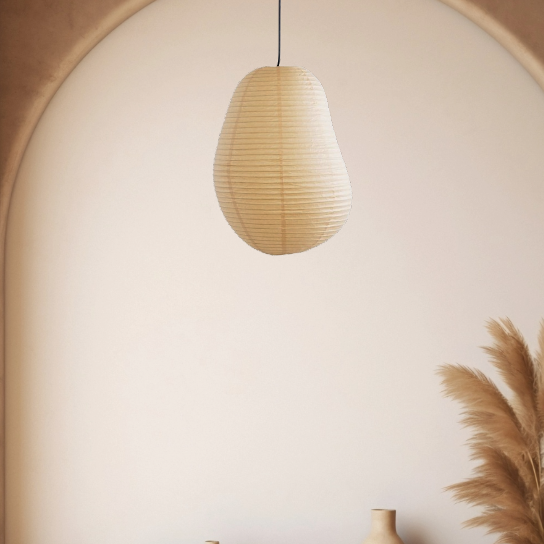 Beige irregular shape paper lampshade hanging in a room with neutral decor.