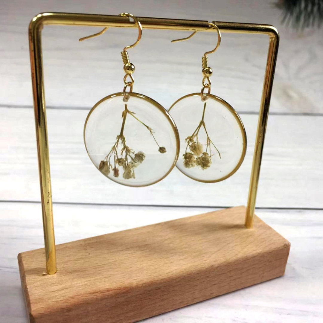 Gold plated pressed flower earrings with delicate dried white flowers encased in clear resin.