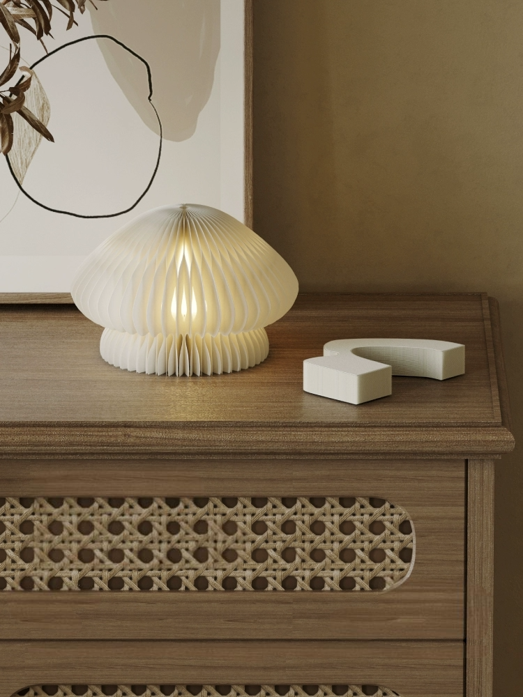 Paper Origami Mushroom Bedside Lamp on a wooden dresser with abstract art in the background.