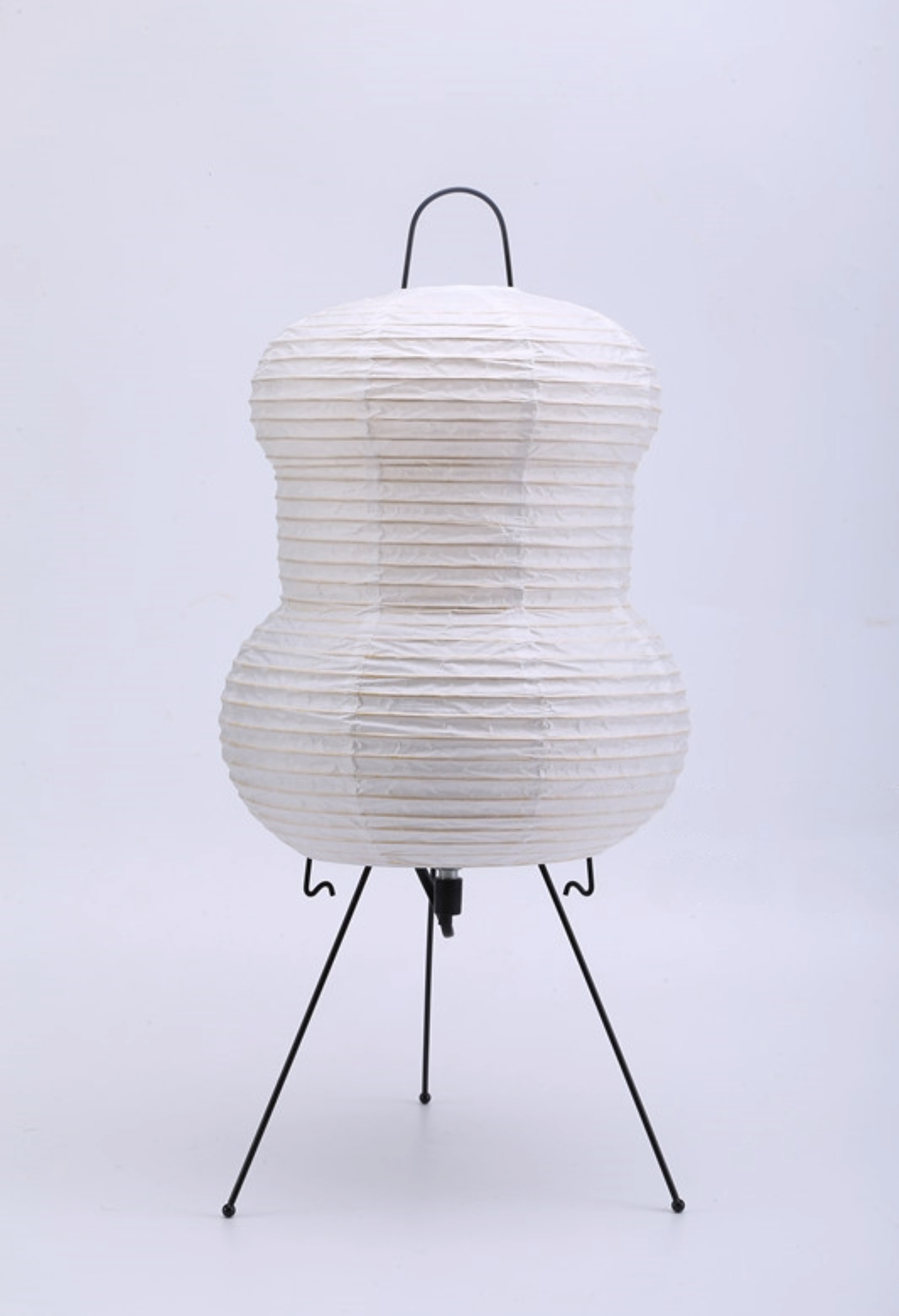 White paper floor lamp on a black tripod stand, modern home decor.