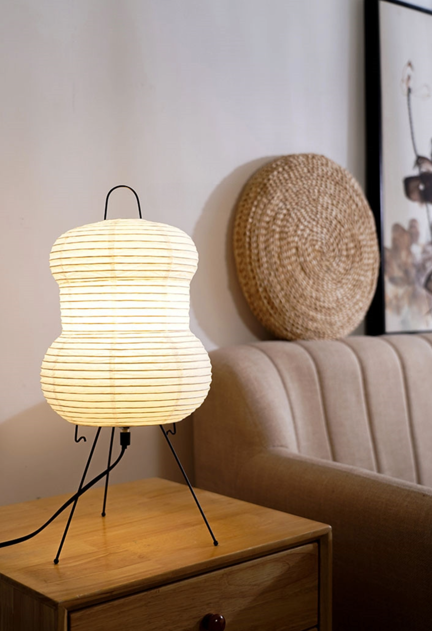 Warm white Floor Paper Lamp with thin horizontal lines, on a wooden table next to a sofa.