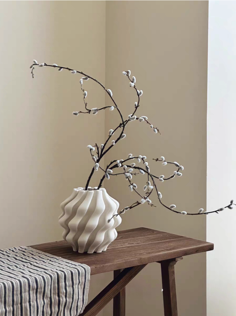 White 3D Printed Vase For Plants with branches on a wooden table.