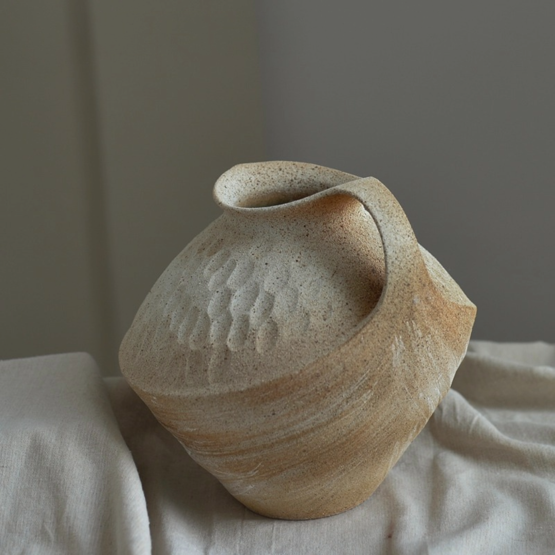 Wabi-sabi clay pot with textured brush effect, natural beige tones, home decor.