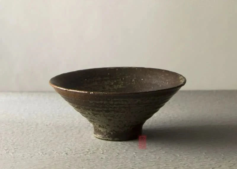 Handmade stoneware brown bowl with textured finish, part of a dinnerware set.