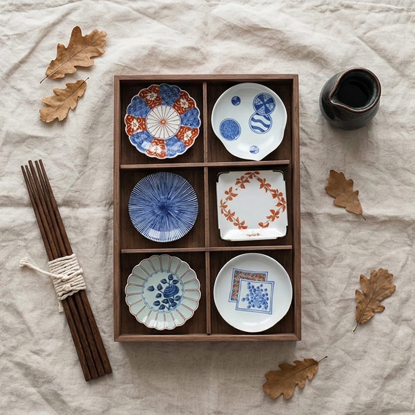 Japanese Arita Ware Ceramic Small Dish Set (6 Pcs) - Kiku Flower Patterned Saucer & Condiment Bowls in Wooden Gift Box — overhead flat-lay on linen surface