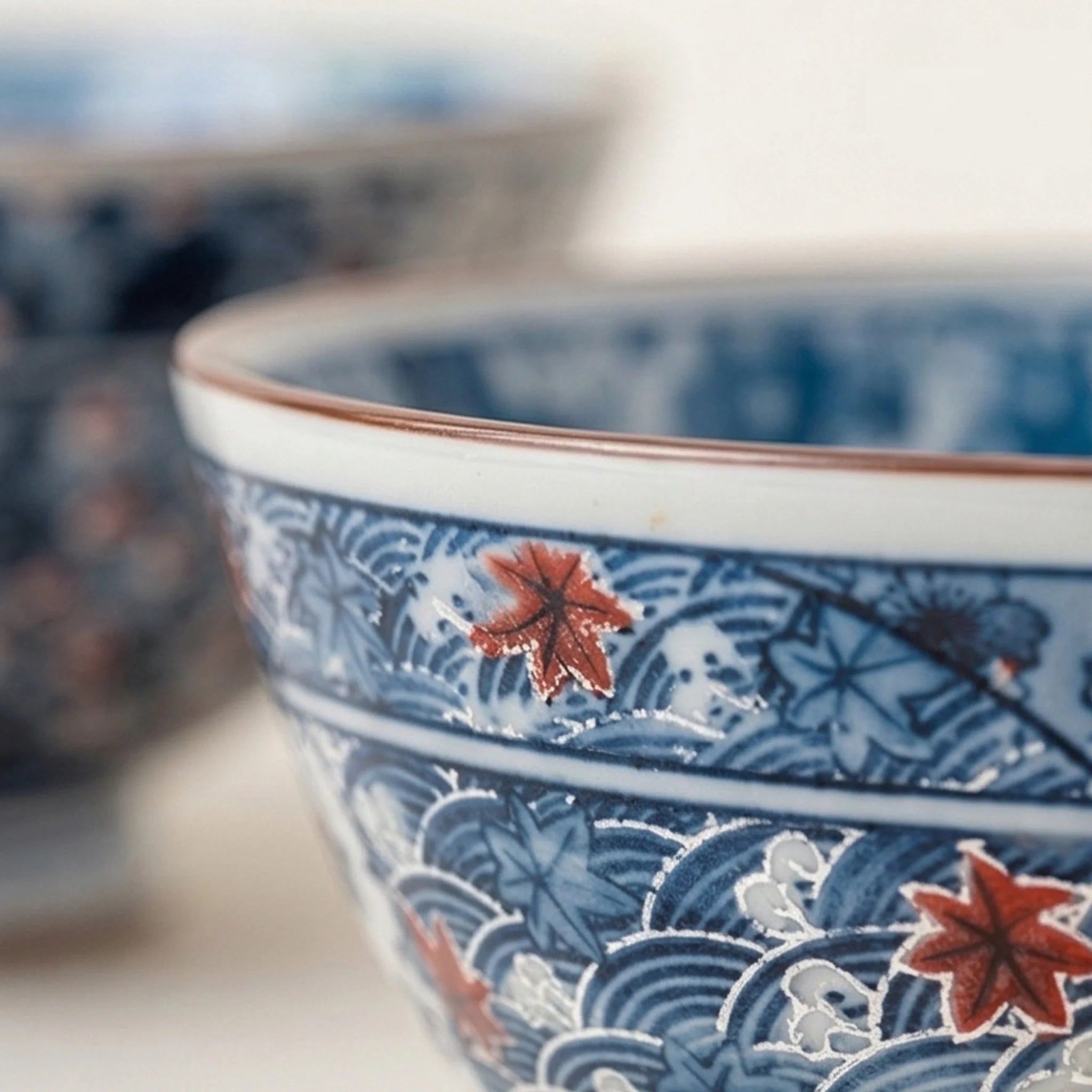 Japanese Style Ceramic Rice Bowl with Auspicious Flower & Wave Pattern - Blue & Red — macro close-up of ceramic glaze texture and finish