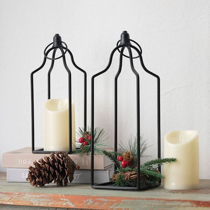 Black metal line candle holder set of 2 with cream pillar candles and pine accents.