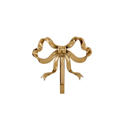 Gleaming brass bow wall hook, a decorative home accent.