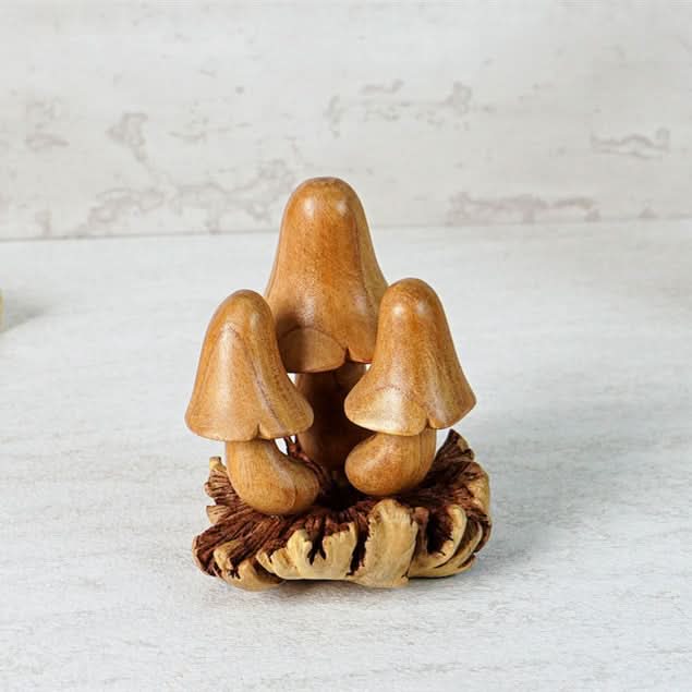 Hand-carved wooden mushroom sculpture in natural wood tones, set on a rustic base.