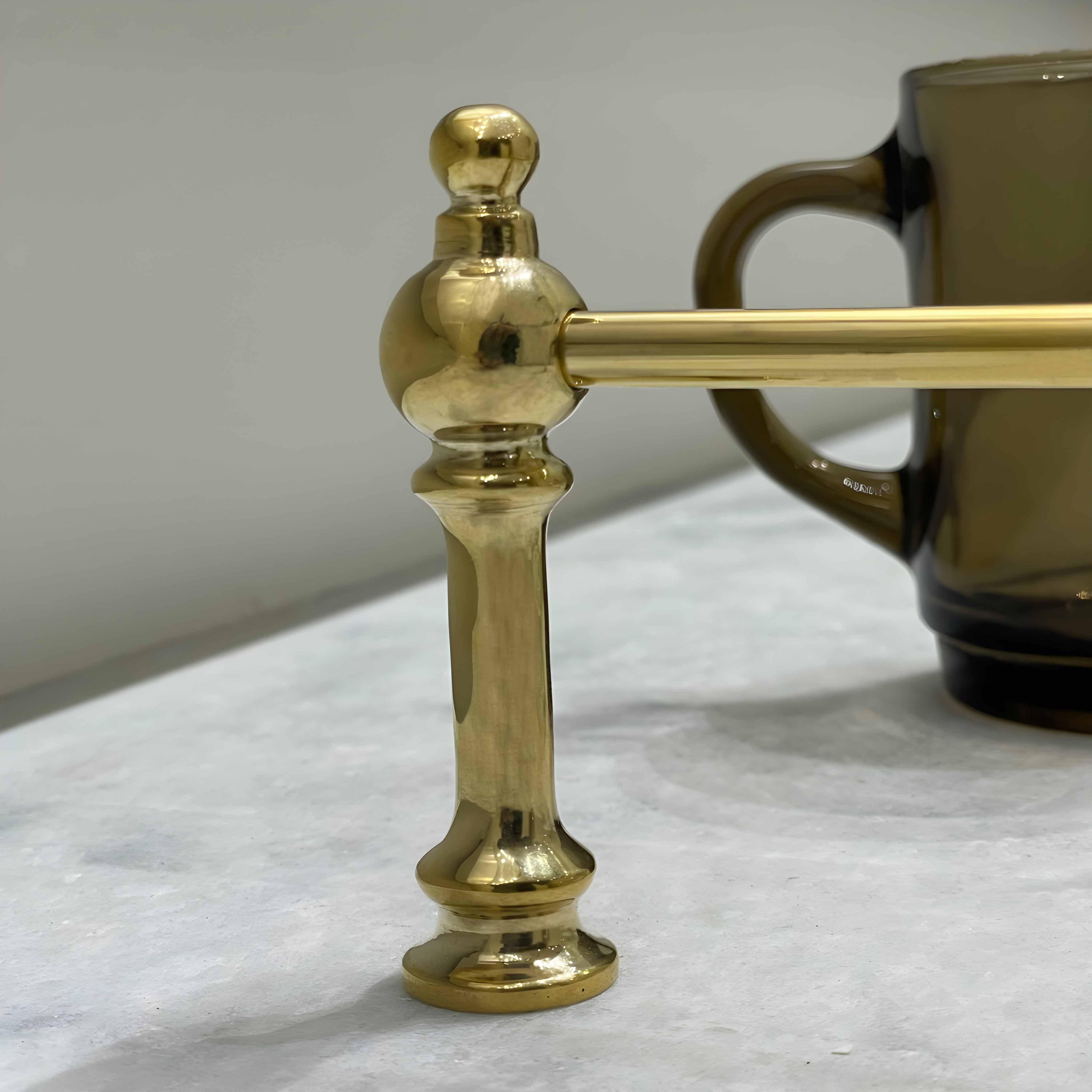Victorian Brass Gallery Rail: Polished brass decorative rail with ornate detailing, next to a tinted glass mug.