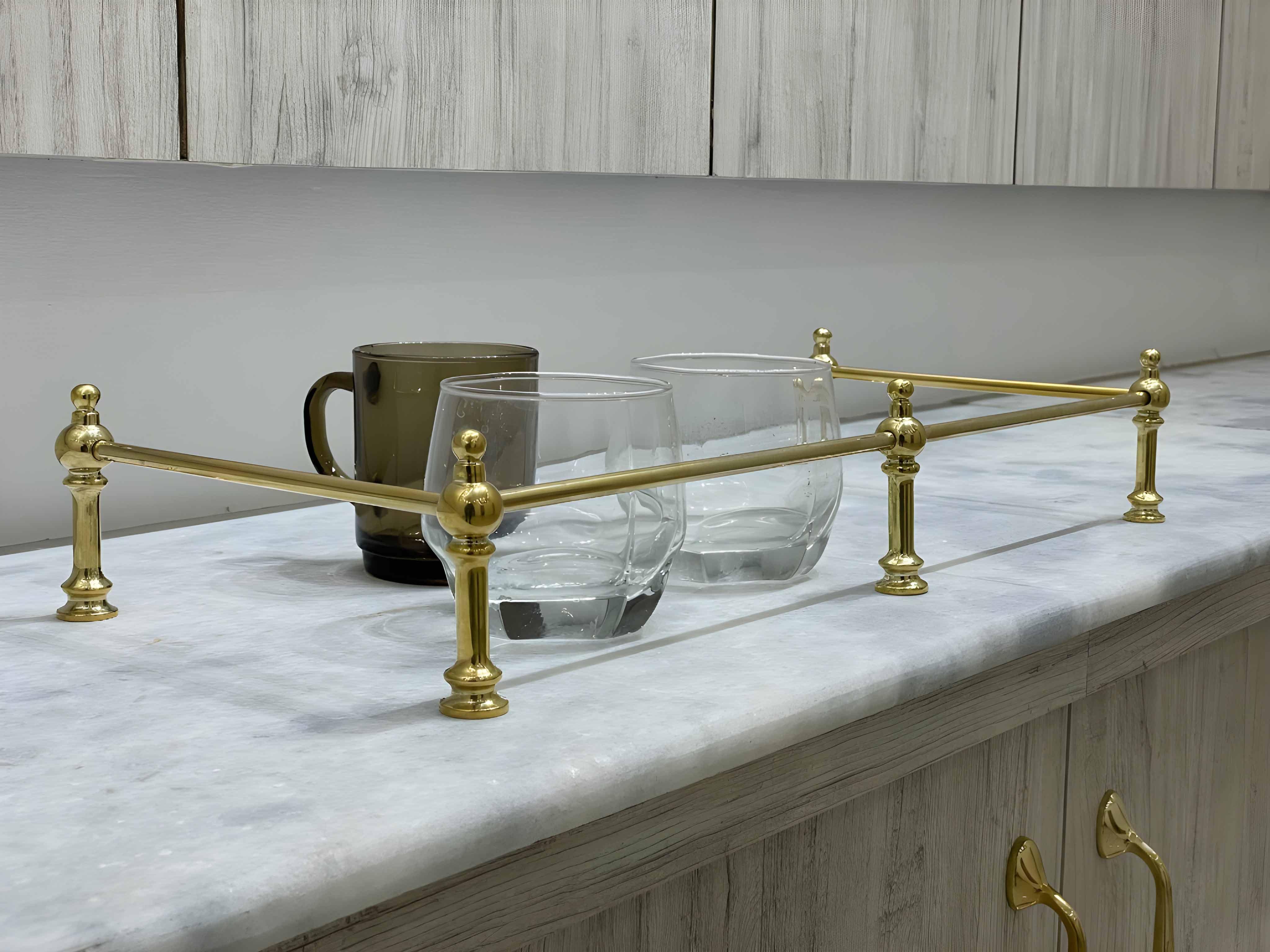 Victorian Brass Gallery Rail - Polished Brass on marble countertop with glasses