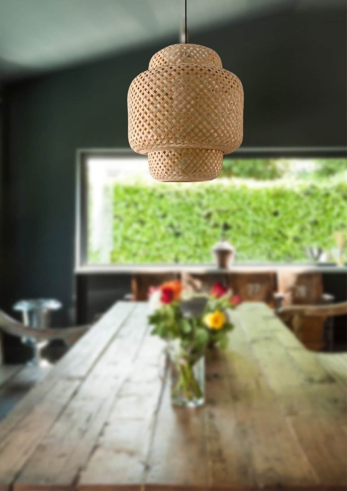 Bamboo Pendant Light: Woven natural bamboo lampshade hanging over a rustic wooden table.