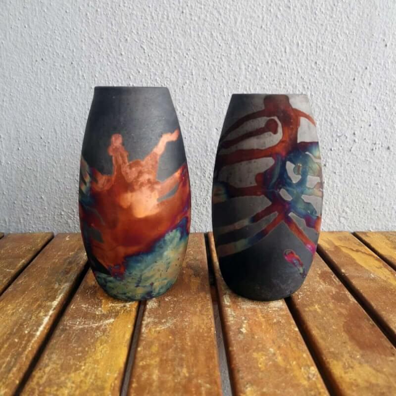 Two raaquu tsuri ceramic vases in smoked raku and copper matte finishes, featuring unique, hand-painted designs.