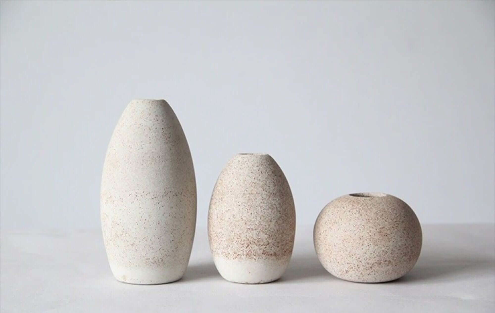 Three textured cream ceramic vases in varying sizes, ideal for home decor.