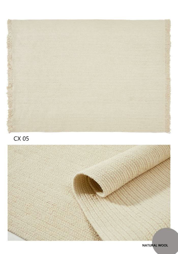 Cream wool braided rug with fringed edges, close-up detail.