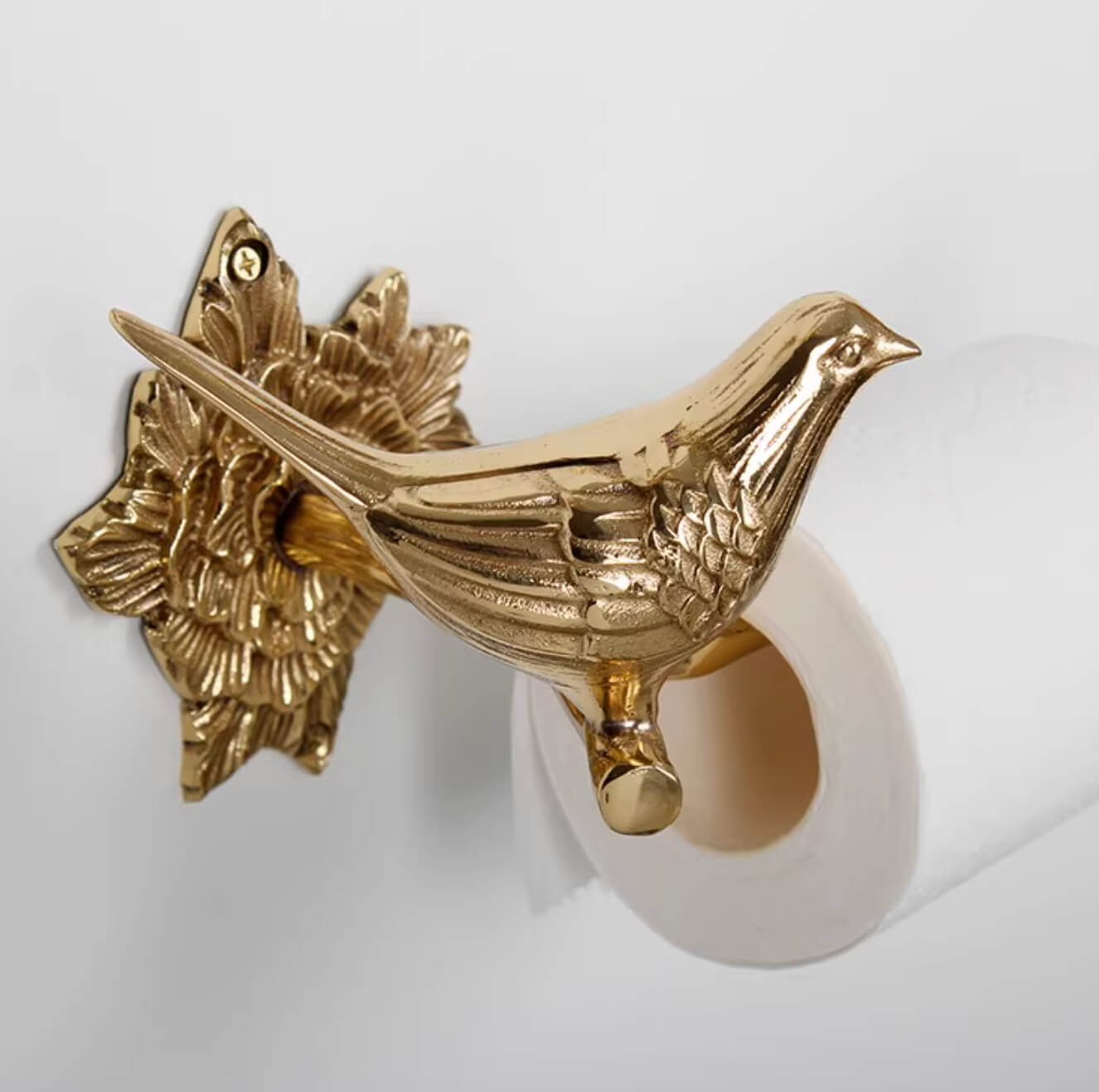 Brass bird toilet paper holder with ornate floral base, part of the Brass Bird Bathroom Set.