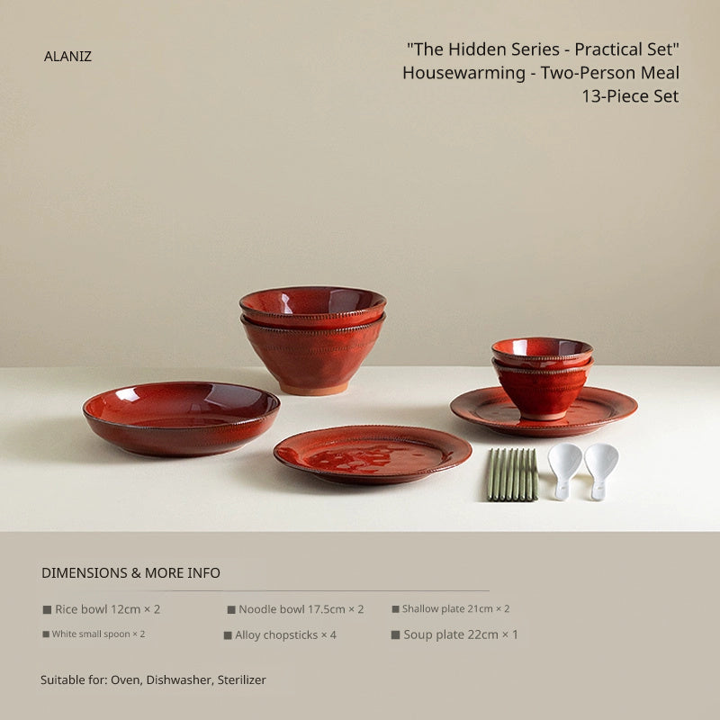 A collection of rustic red ceramic dinnerware, including bowls and plates, arranged on a plain surface.