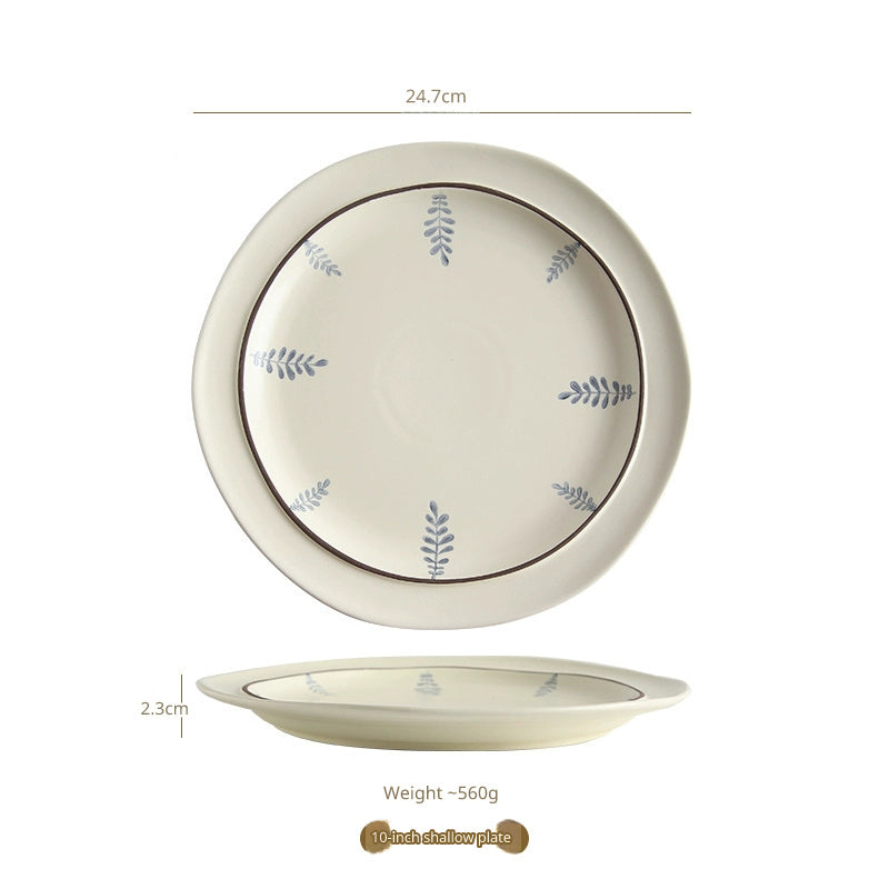 A white ceramic plate with a brown rim and blue leaf pattern, shown from top and side views.