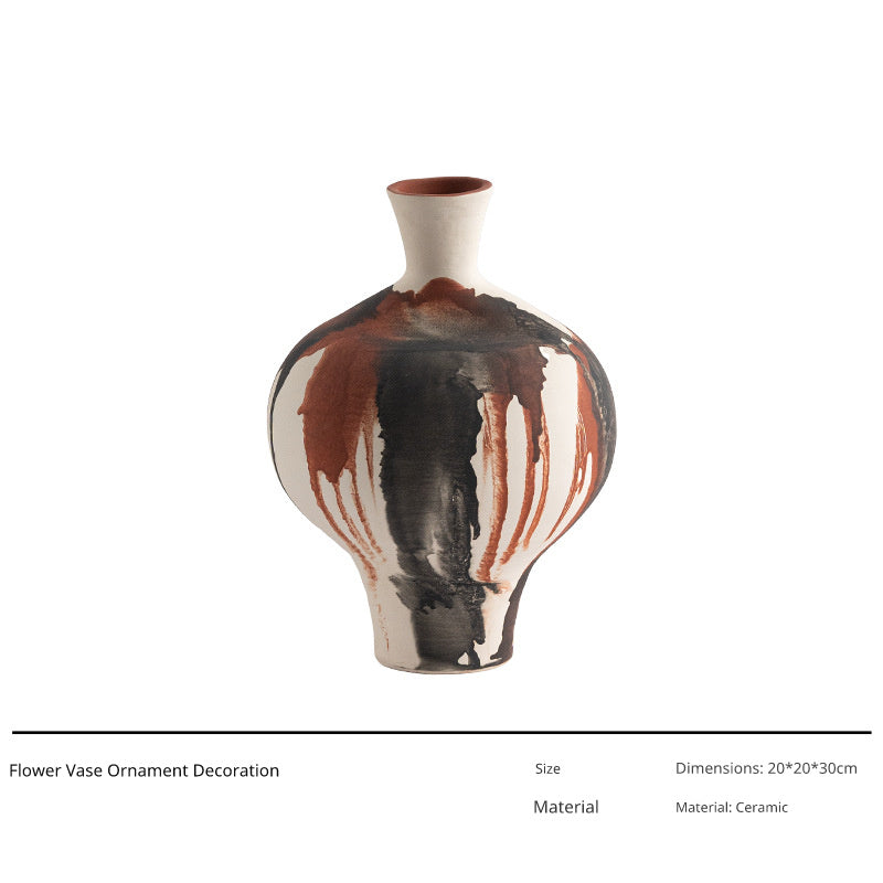 A ceramic vase with a bulbous body and narrow neck, featuring a dripping glaze pattern of brown and black over a white base.