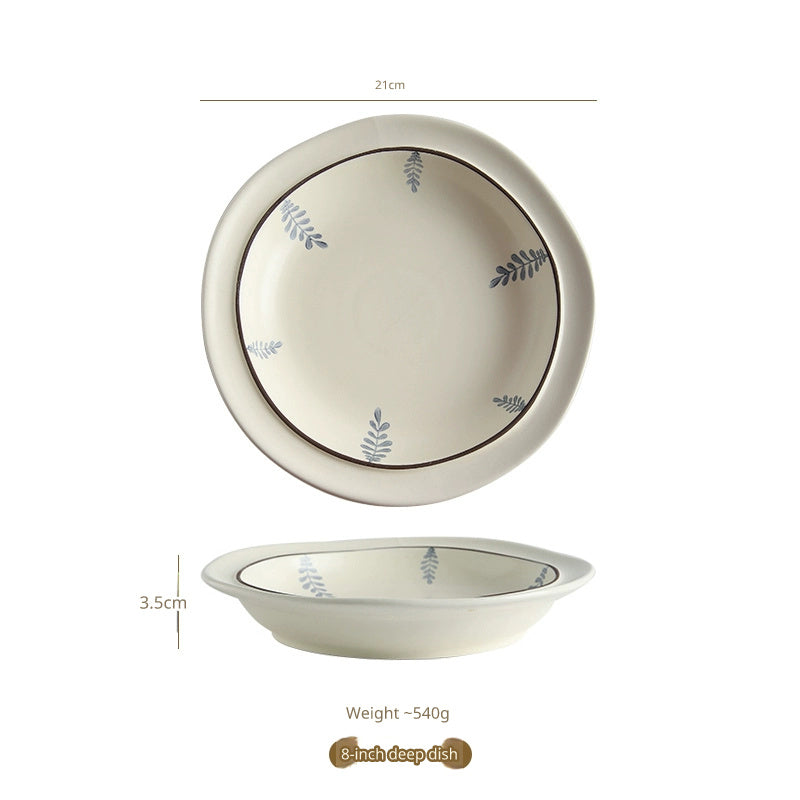 A top-down and side view of a cream-colored ceramic plate with a delicate blue leaf pattern and a brown rim, with measurements indicated.