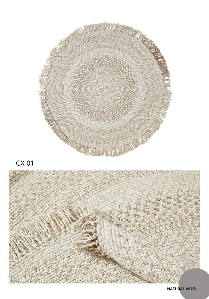 Round wool braided rug in natural tones with fringe detail. Home decor.