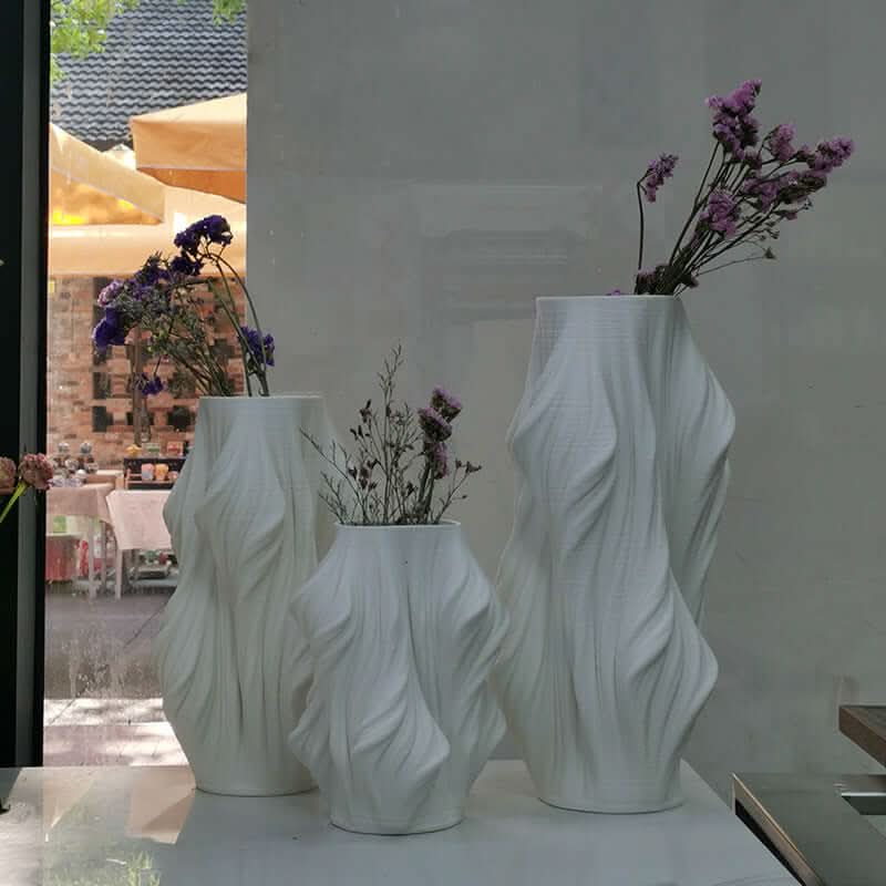 Three white 3D printed ceramic vases with dried flowers, modern home decor.