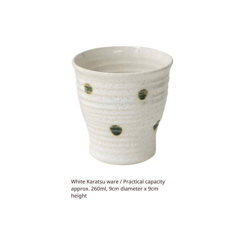 Studio shot of a cream white ceramic Yunomi cup with green spots, text description below.