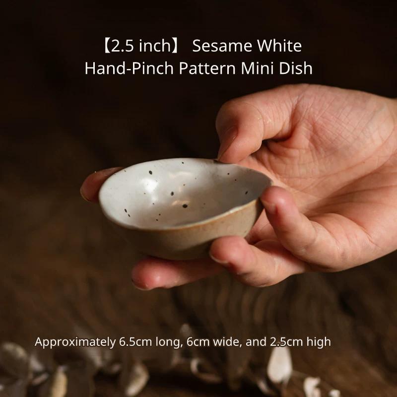 A medium, oval, irregular-shaped ceramic plate with a speckled off-white glaze on wood.