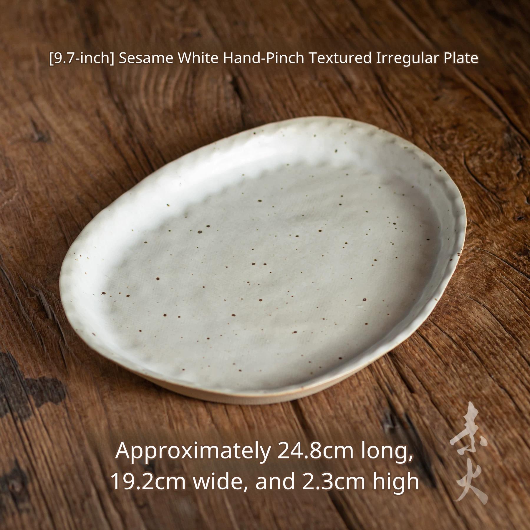 A very large, slightly oval, irregularly shaped serving platter with speckled white glaze on wood.
