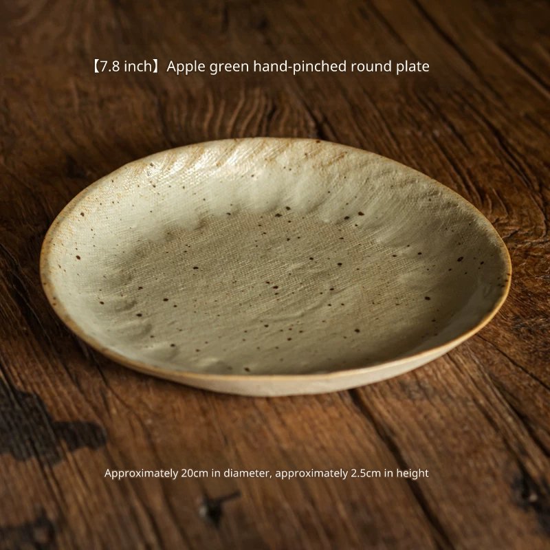 Close-up of a 7.8-inch speckled apple green ceramic plate (20cm diameter) on dark wood.