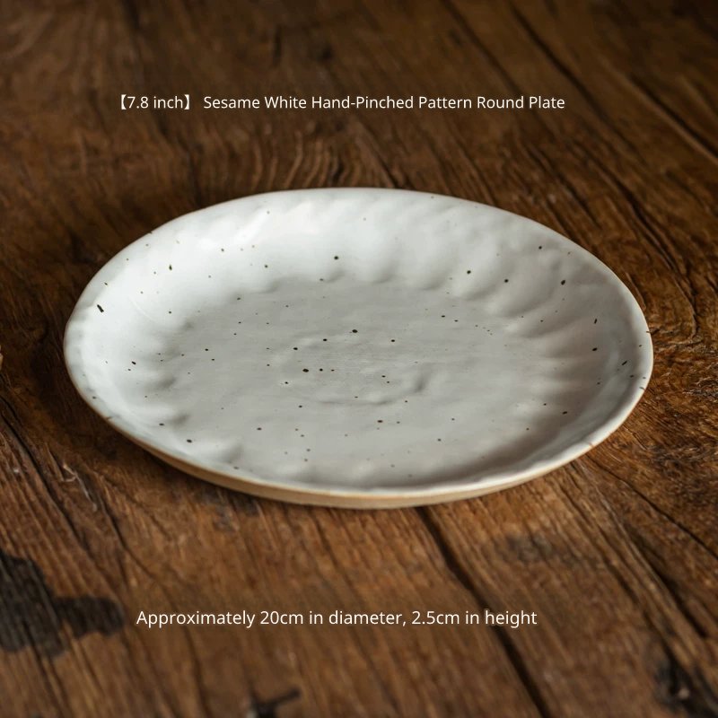 Close-up of a 7.8-inch speckled white ceramic plate (20cm diameter) with a hand-pinched rim on wood.