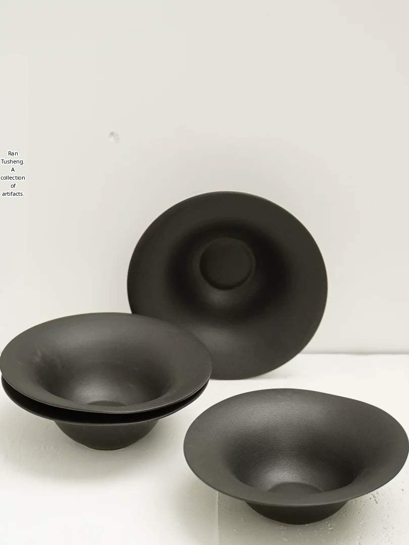 Selection of three matte black minimalist ceramic bowls of varying sizes