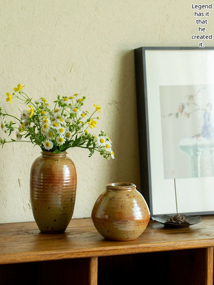 A handmade ceramic vase featuring a textured, multi-toned kiln-changed glaze in a minimalist shape.