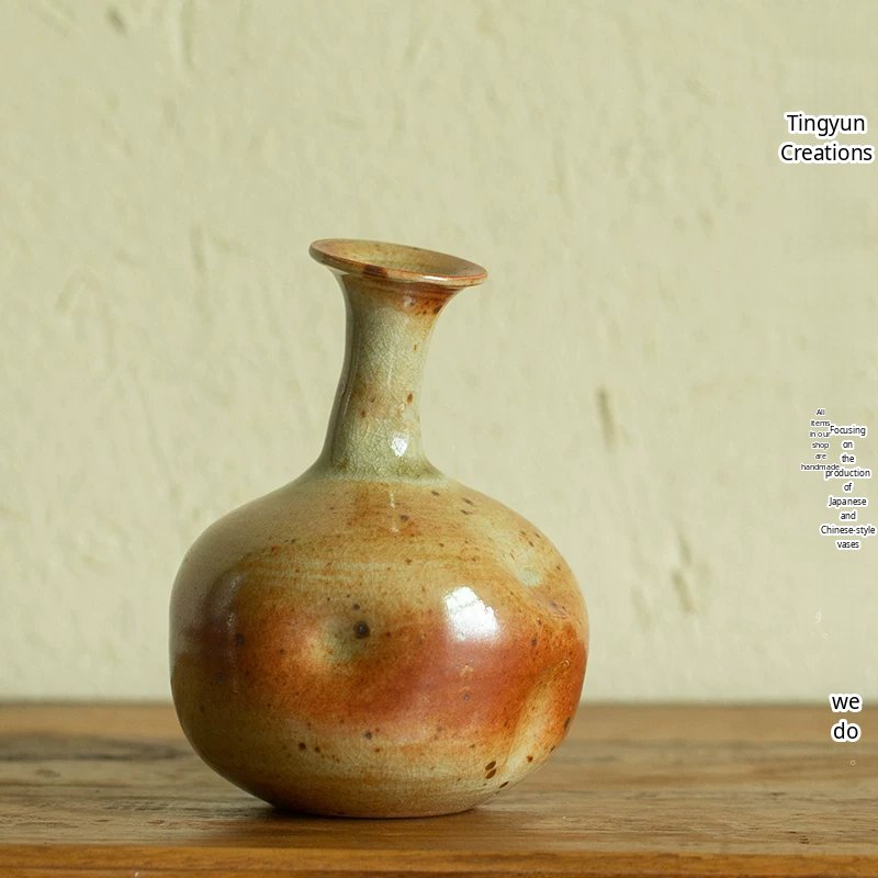 A minimalist handmade ceramic vase featuring a unique speckled glaze in earthy tones.