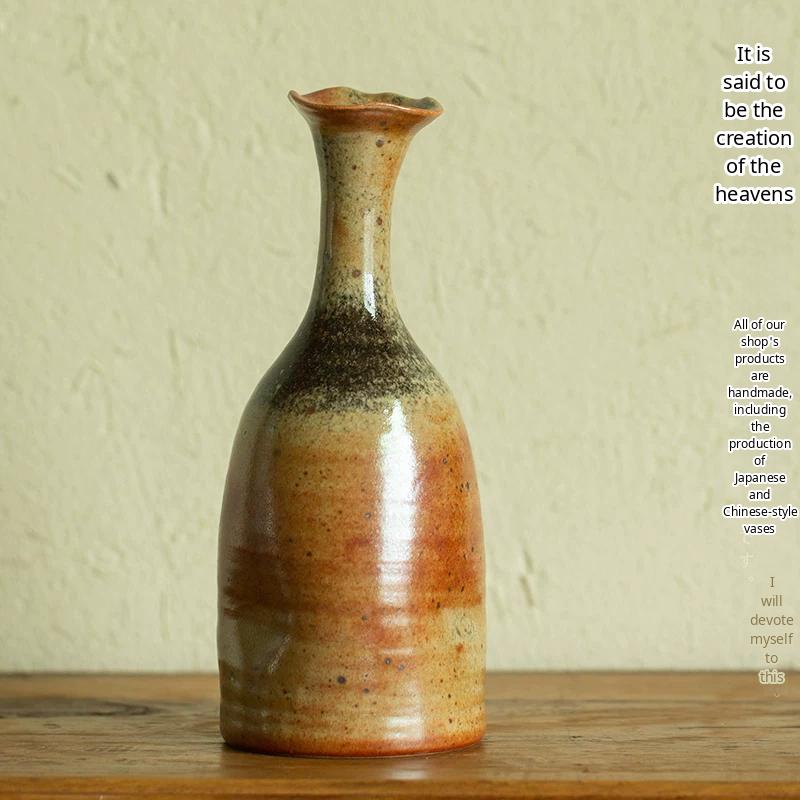 A textured handmade ceramic vase with a unique blue and brown glaze on a neutral background.