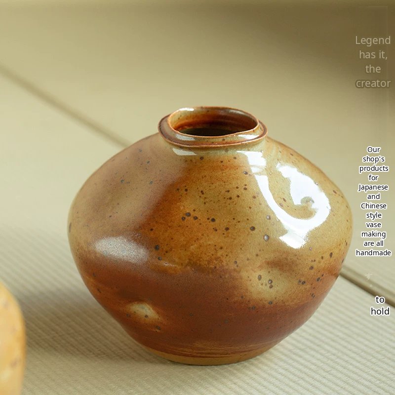 A handmade ceramic vase with a glossy, speckled multicolored glaze and a wide cylindrical body.