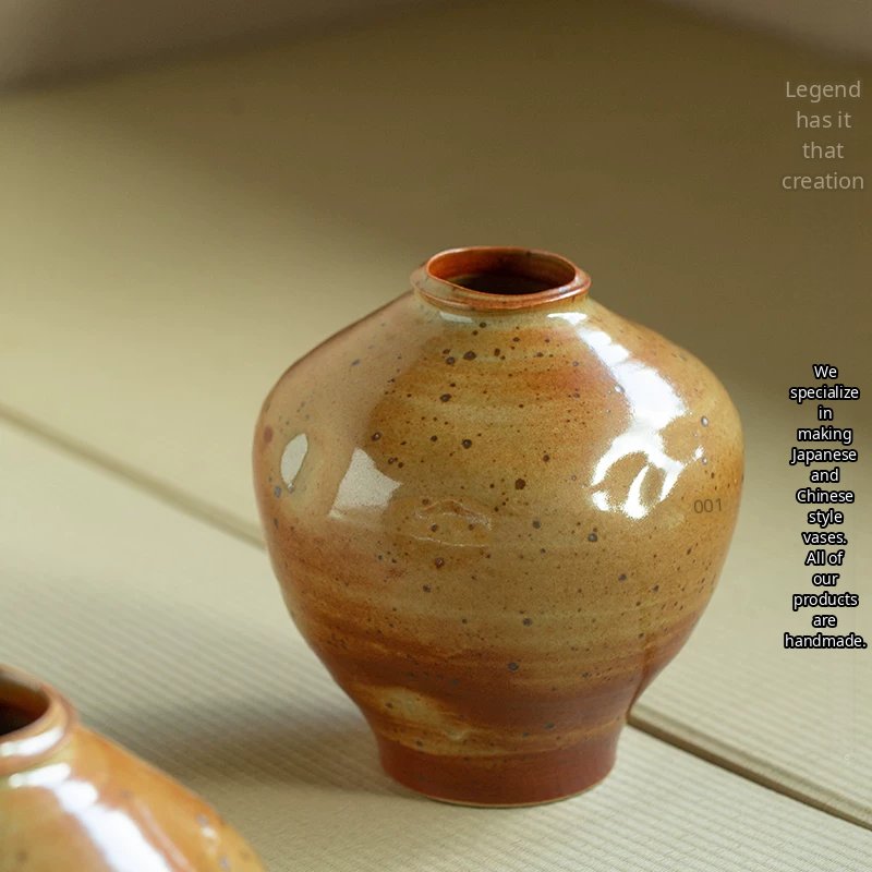 A handmade ceramic vase featuring a unique speckled glaze and a minimalist silhouette.