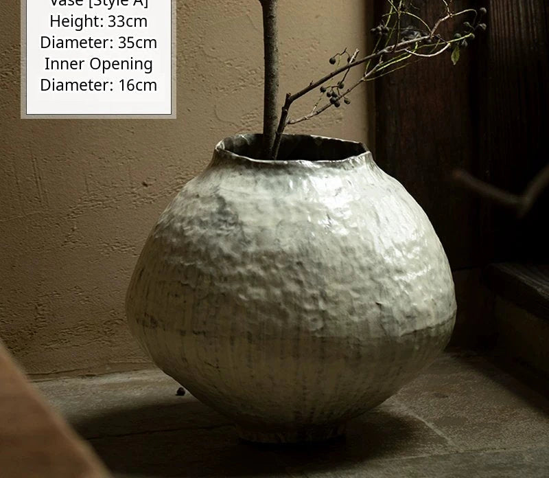 A handmade black glossy ceramic vase with a unique artisan shape and smooth finish.