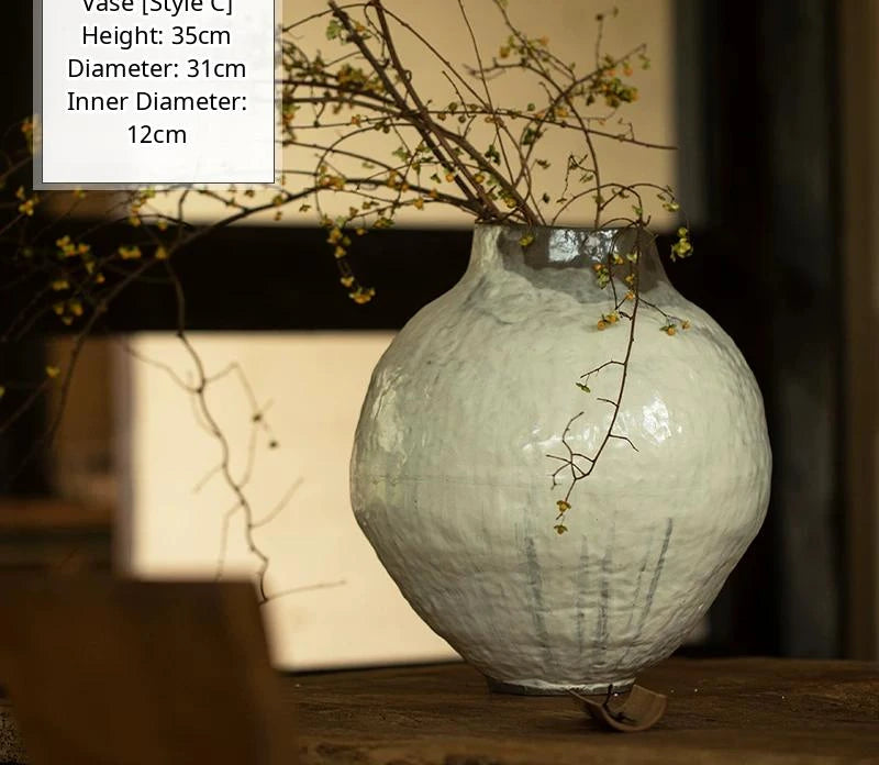 A handmade black glossy ceramic vase with a unique artisan shape and smooth reflective finish.