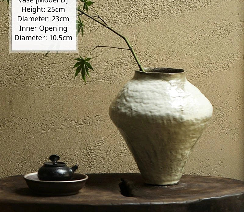 A handmade black glossy ceramic vase with an organic, asymmetrical shape on a surface.