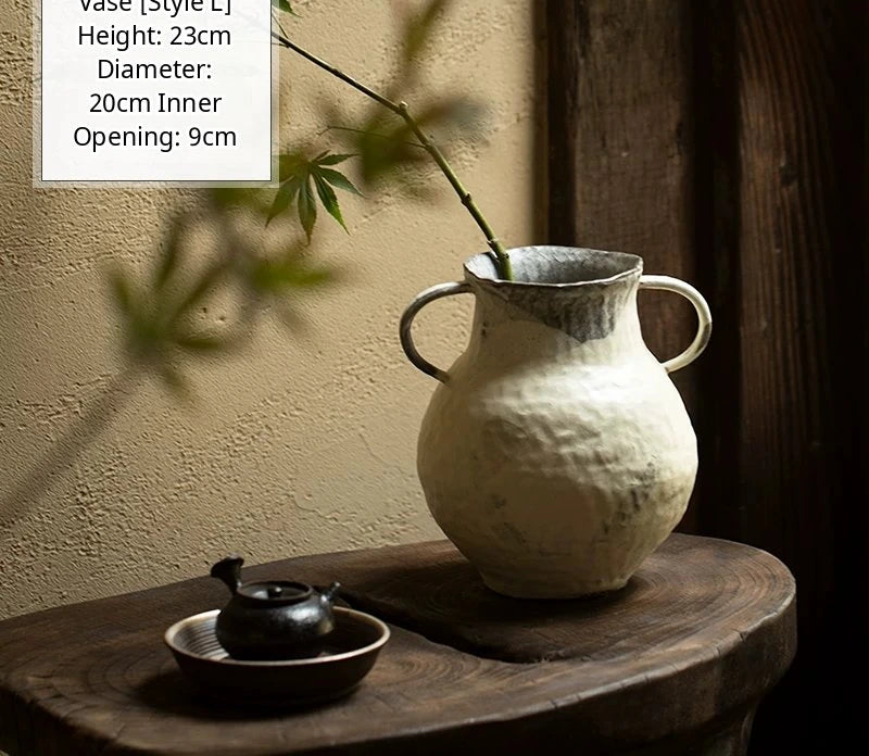 A handmade black glossy ceramic vase with an organic, asymmetric shape and a smooth finish.