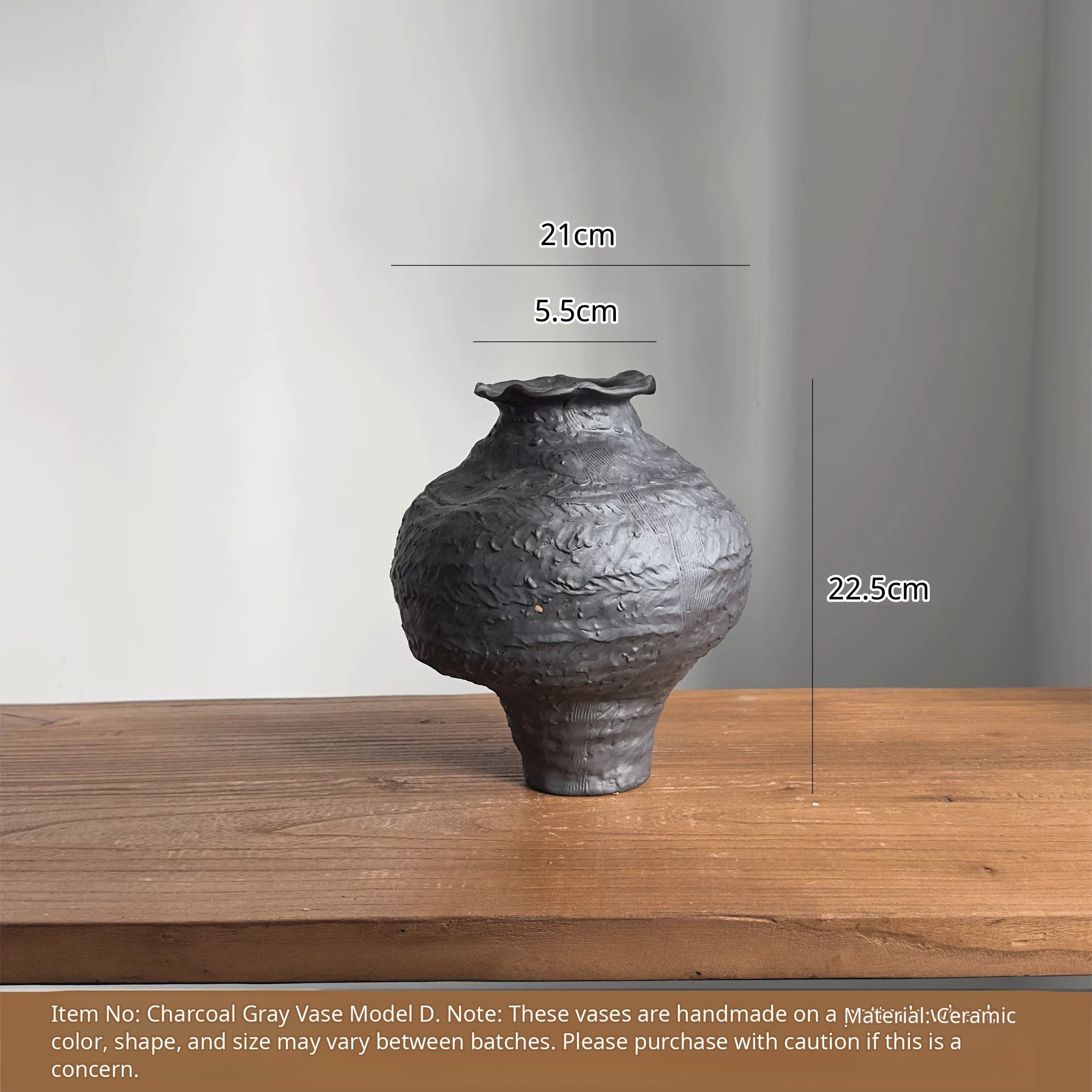 A handmade black ceramic vase with a textured clay finish and an artistic sculptural design.