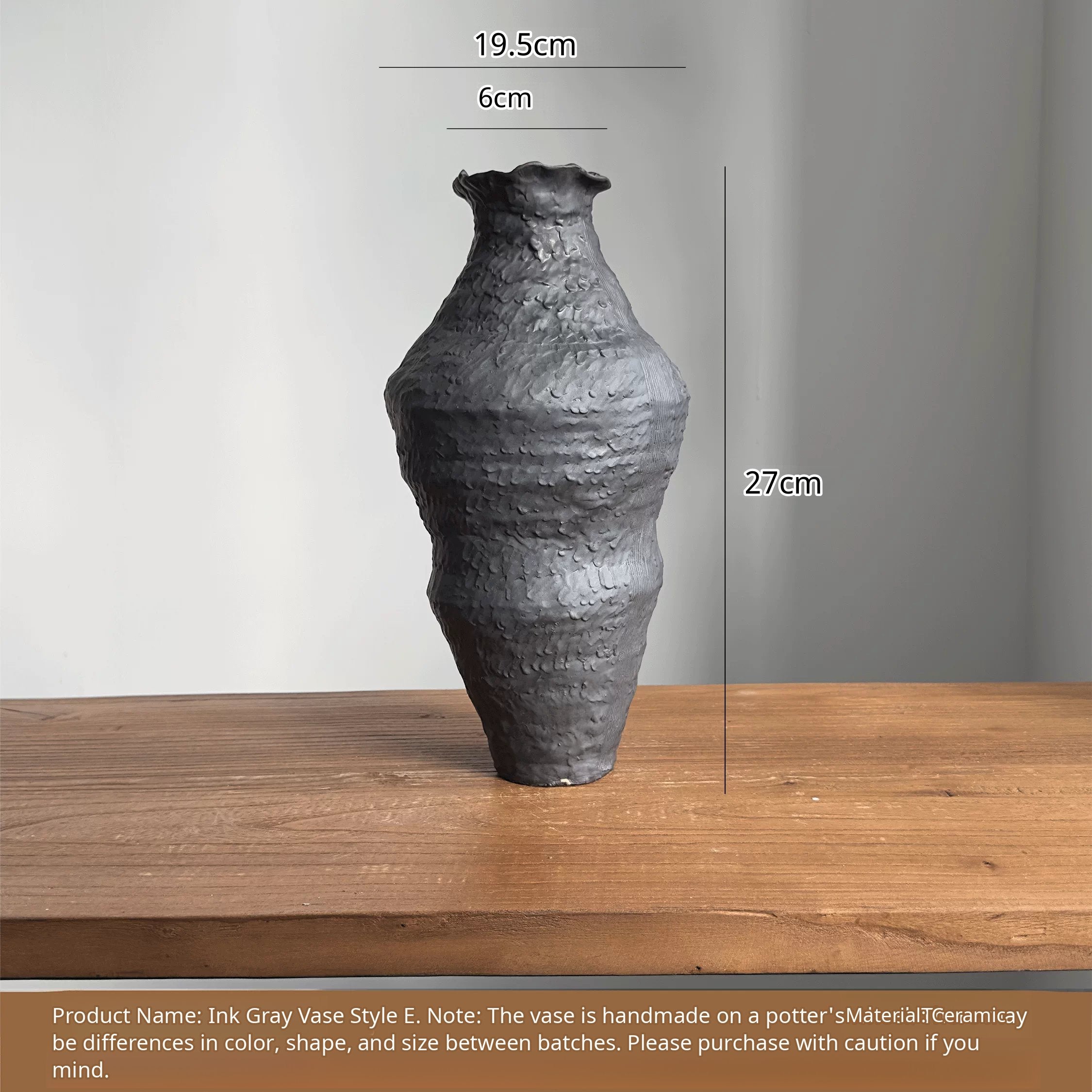 A handmade black ceramic vase with a textured clay finish and an artistic sculptural design.